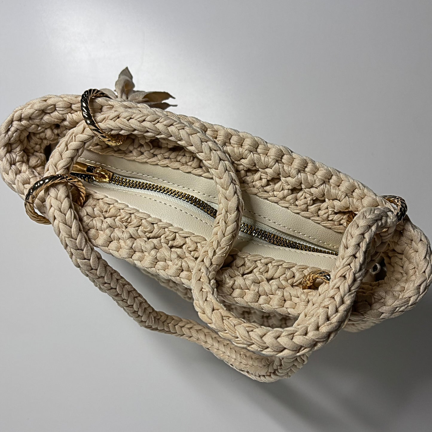 Beige handbag with a zipper on a light gray background