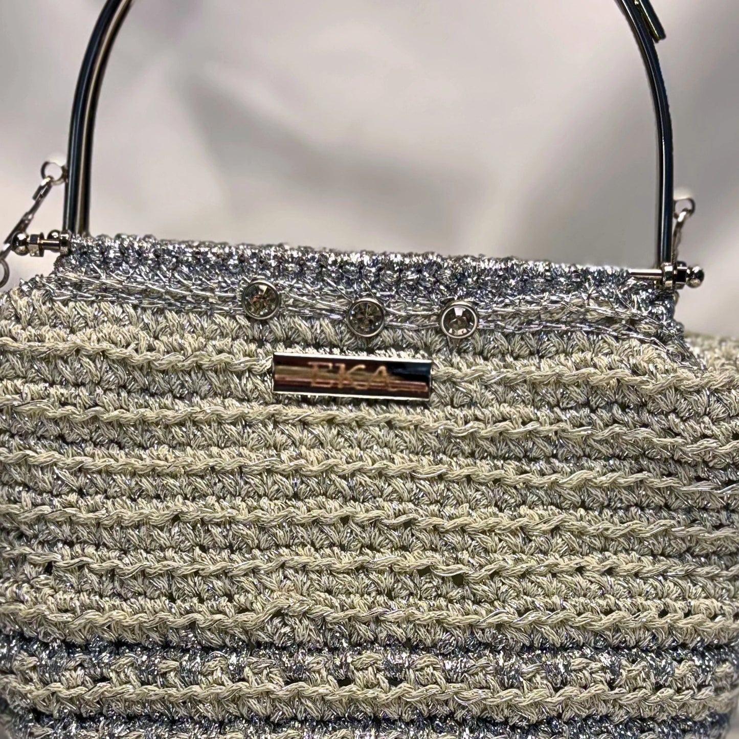 Close up of a crochet bag with crystals over a bright background