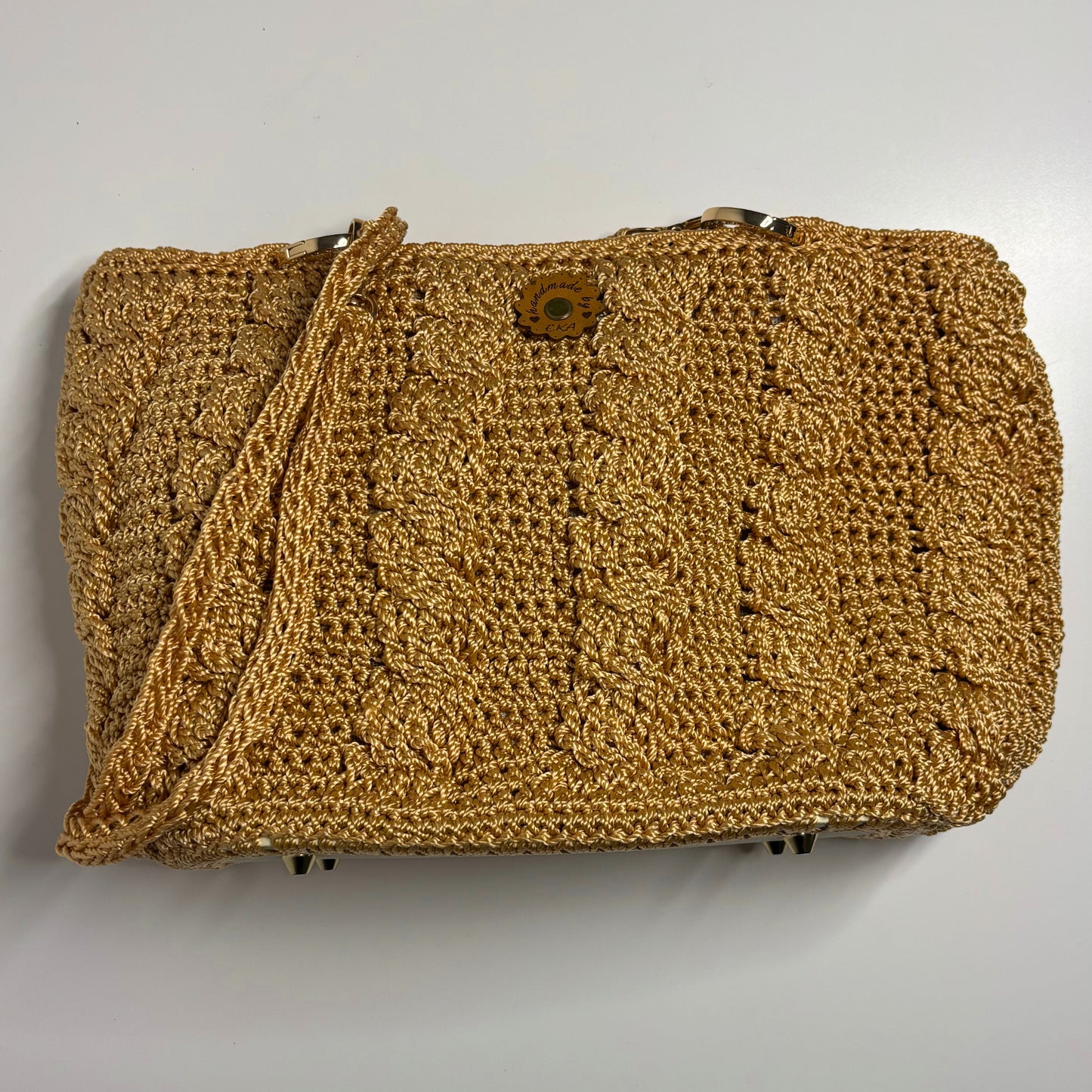 Gold crochet bag on a light gray background