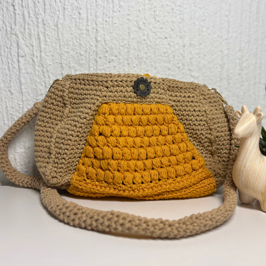Crocheted bag with a yellow front panel and beige strap on a white background