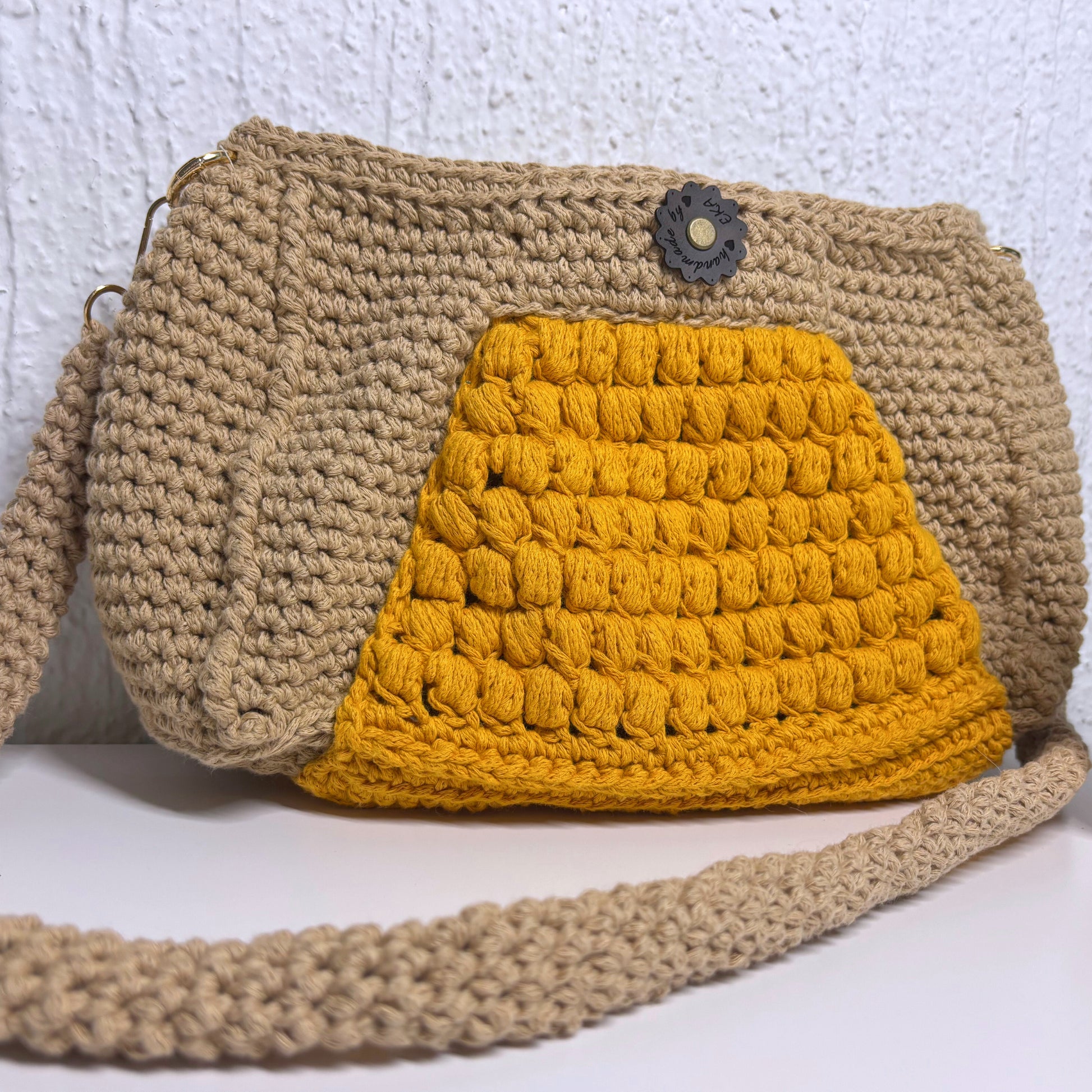 Crocheted beige and yellow bag on a white background