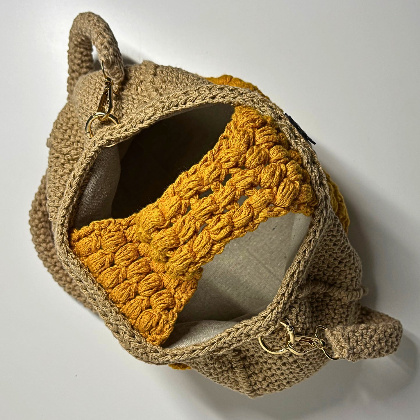 Brown crochet bag with a yellow detail on a white background