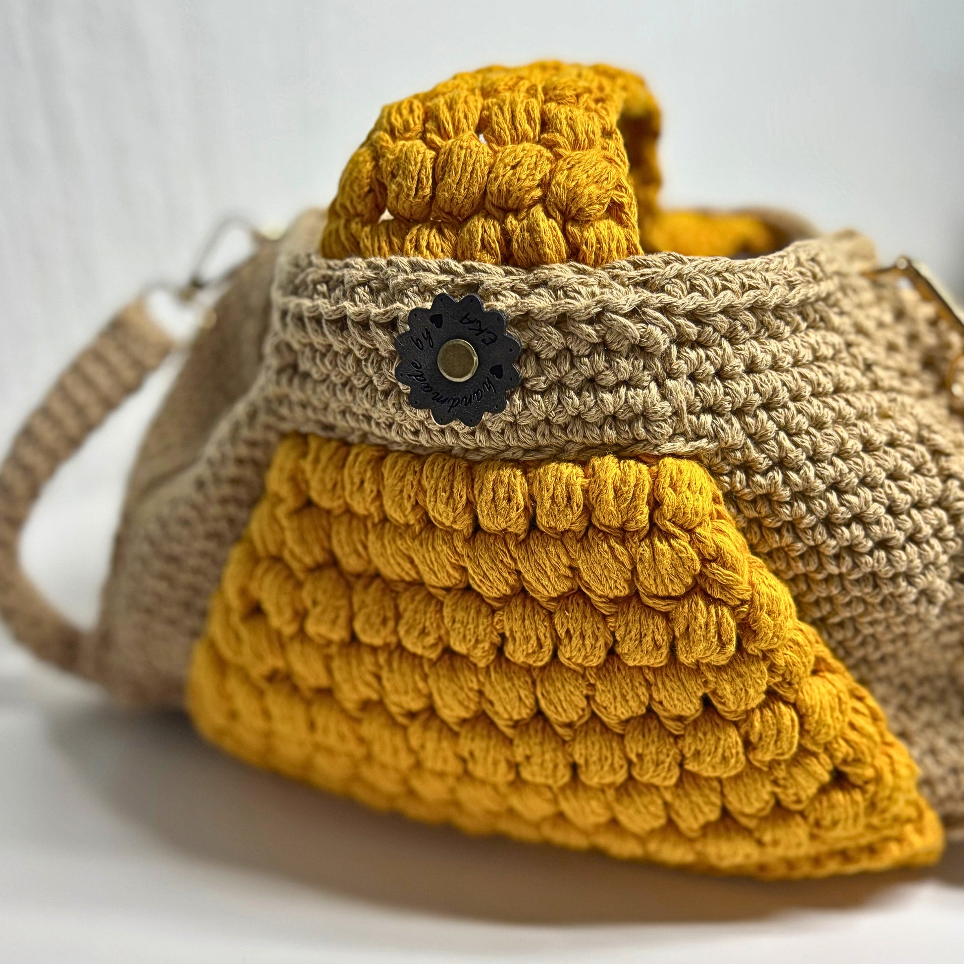 Crocheted bag with yellow and beige pattern on a white background