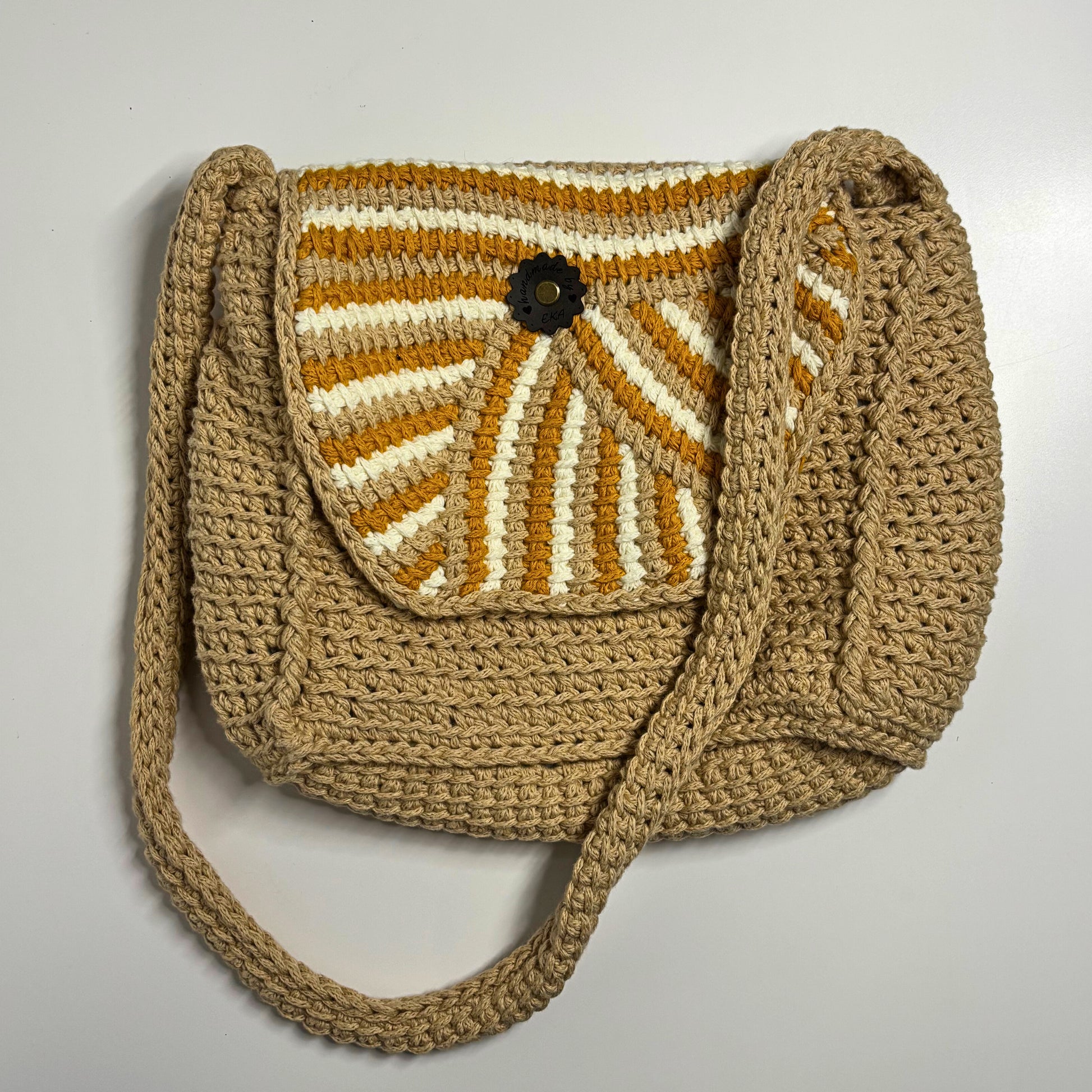 Crocheted bag with a sunburst pattern on a light gray background