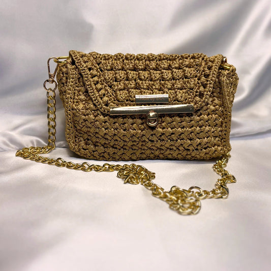 Golden woven handbag with a gold chain on a white background
