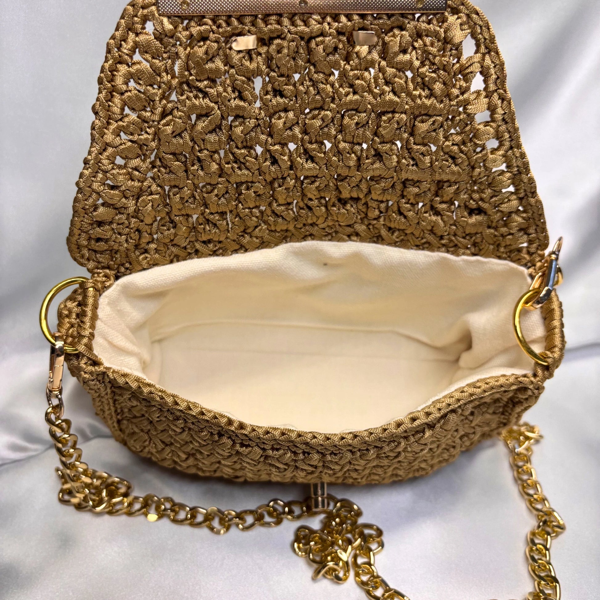 Woven handbag with gold chain strap on a white background