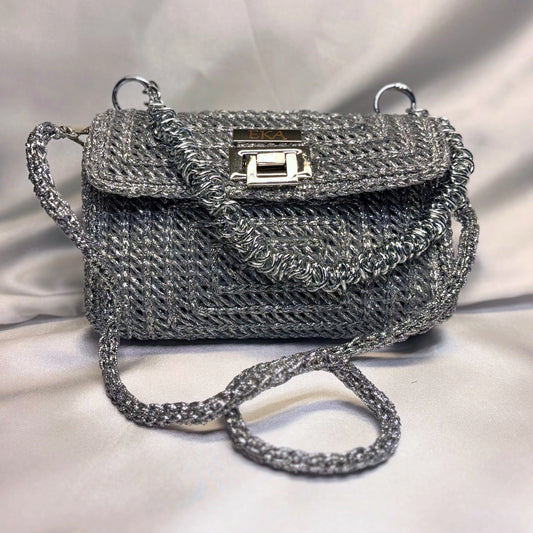 Silver crochet handbag on a light fabric background