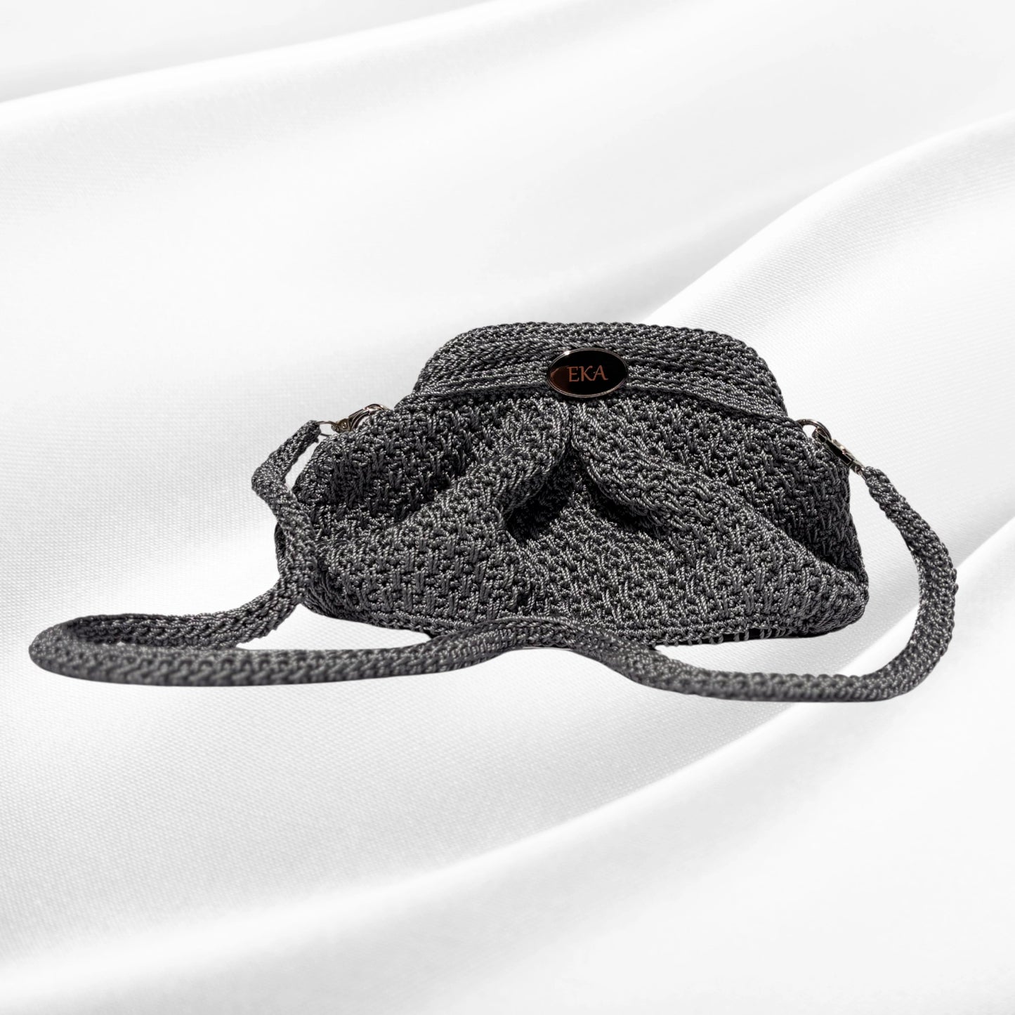 Silver crochet purse on a white background.