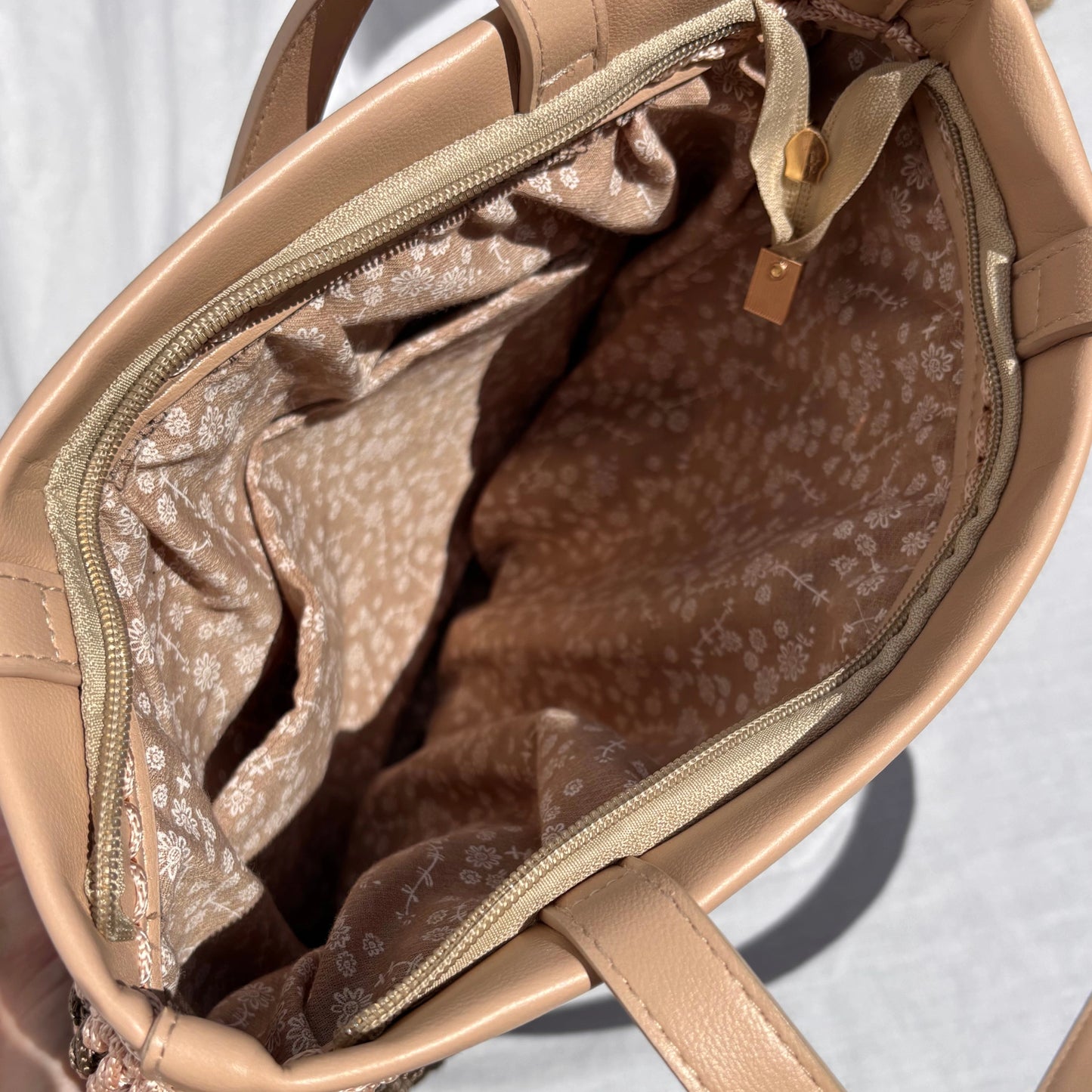 Looking down into the open Fiona tote bag, displaying the secure top zip closure, soft floral-printed fabric lining, and internal slip pocket.