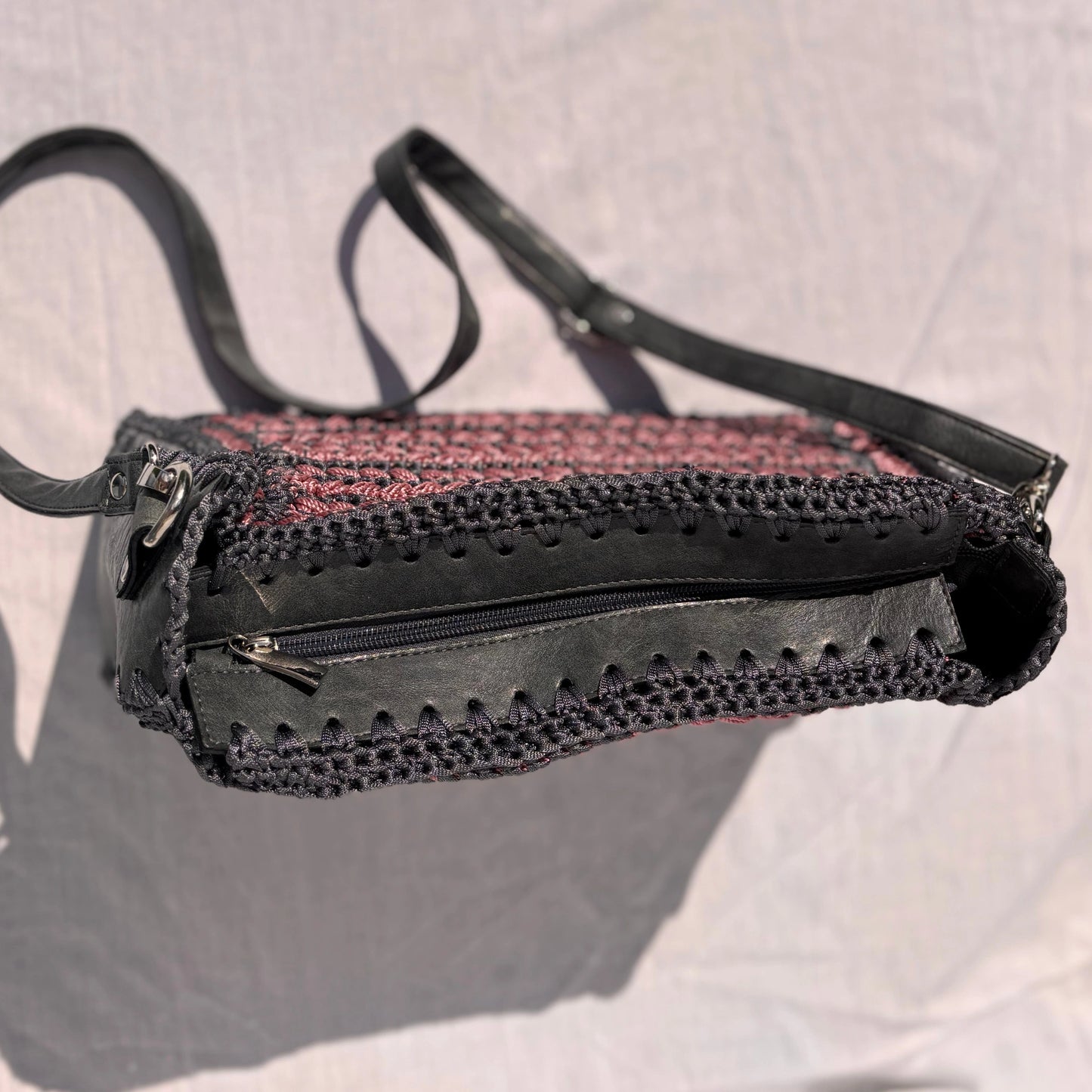 Top-down view of the Gloria purse closed, showing the black real leather top panel, sturdy zipper closure, and silver-toned strap clips.