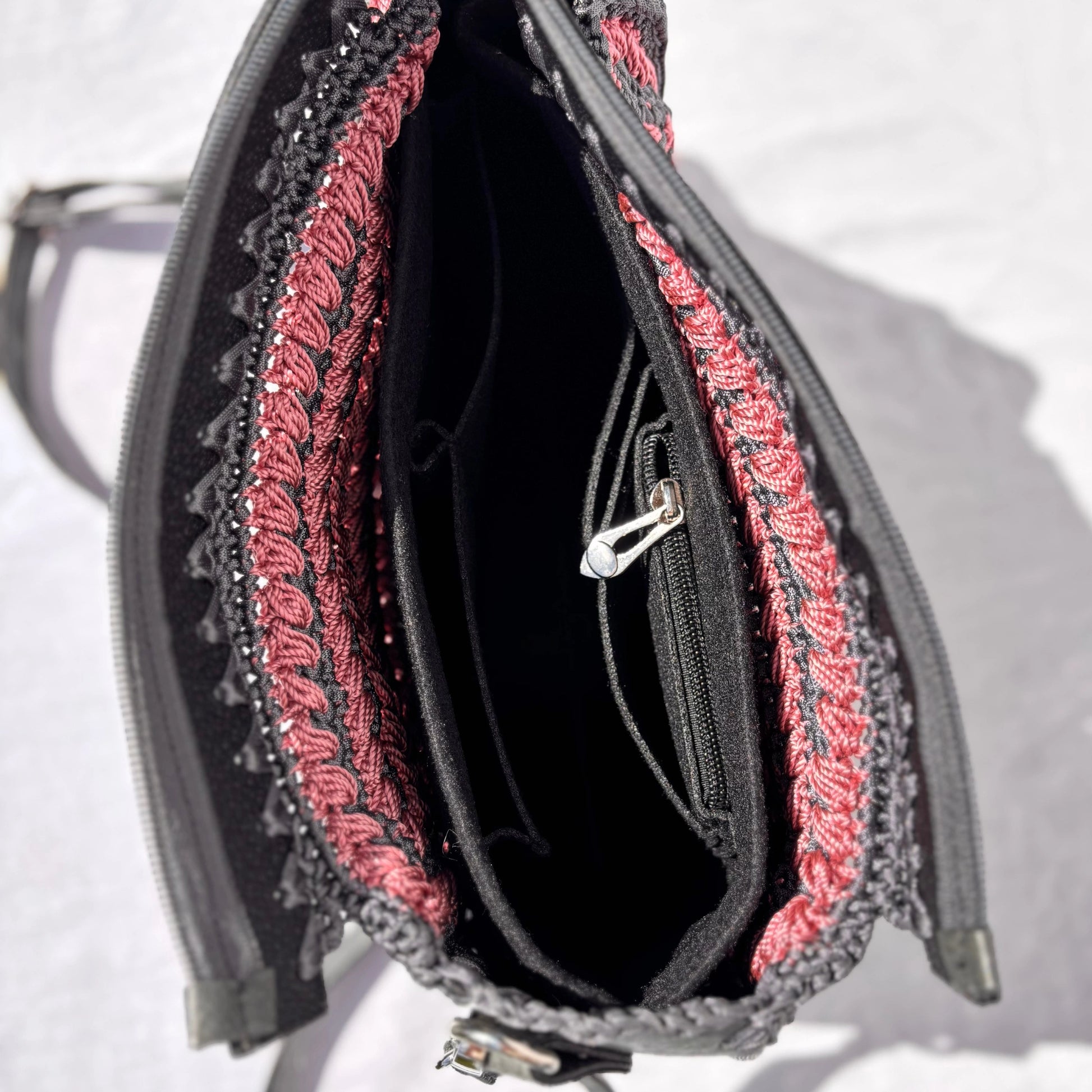 Looking down into the open Gloria bag, revealing the black interior lining, an internal zippered pocket, and open slip compartments.