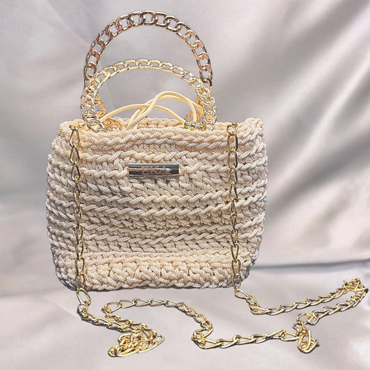 Crochet handbag with gold chain details on a light background