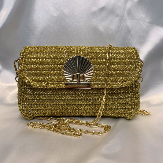 Gold crochet handbag with a chain strap on a light gray background