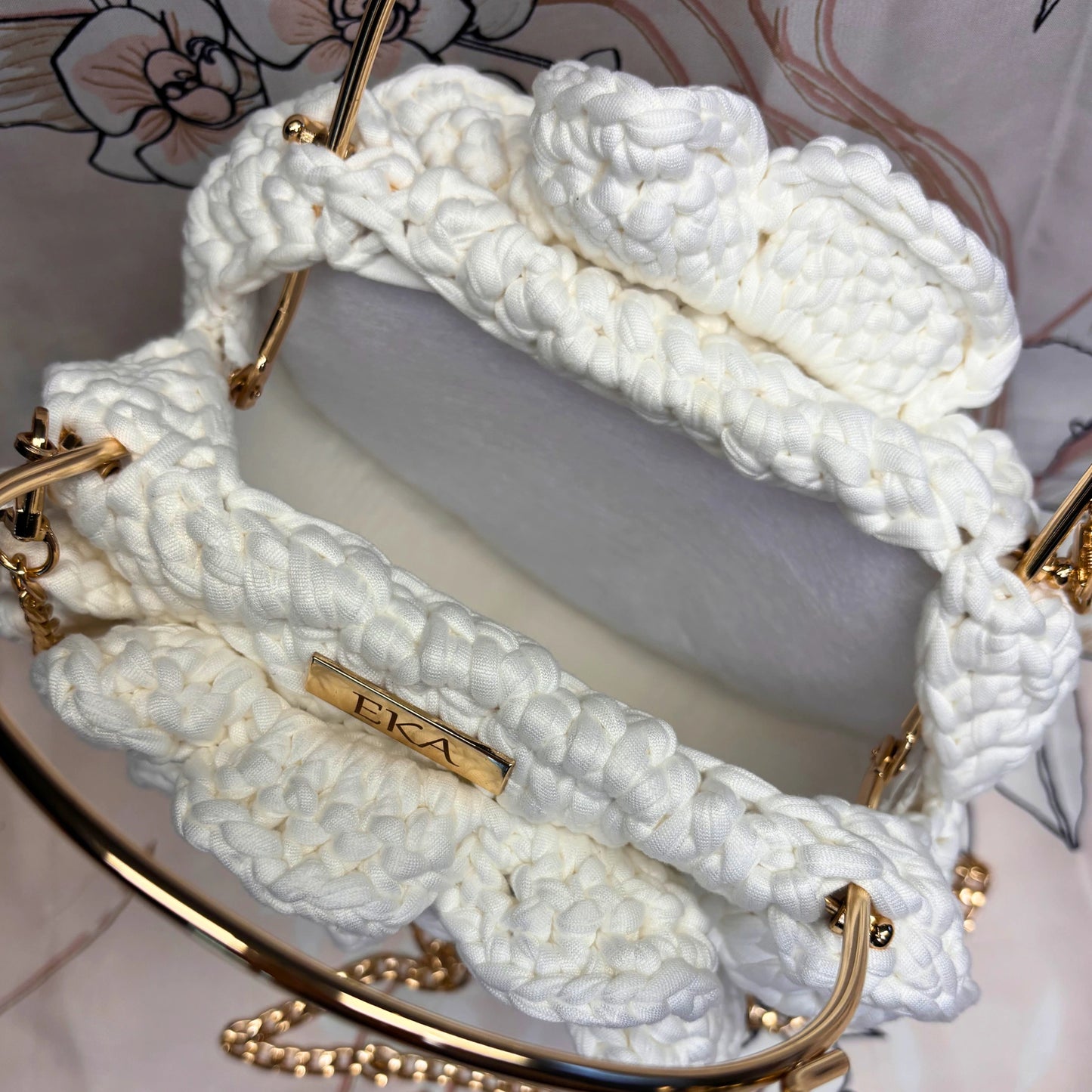 White braided handbag with gold accents on a white background