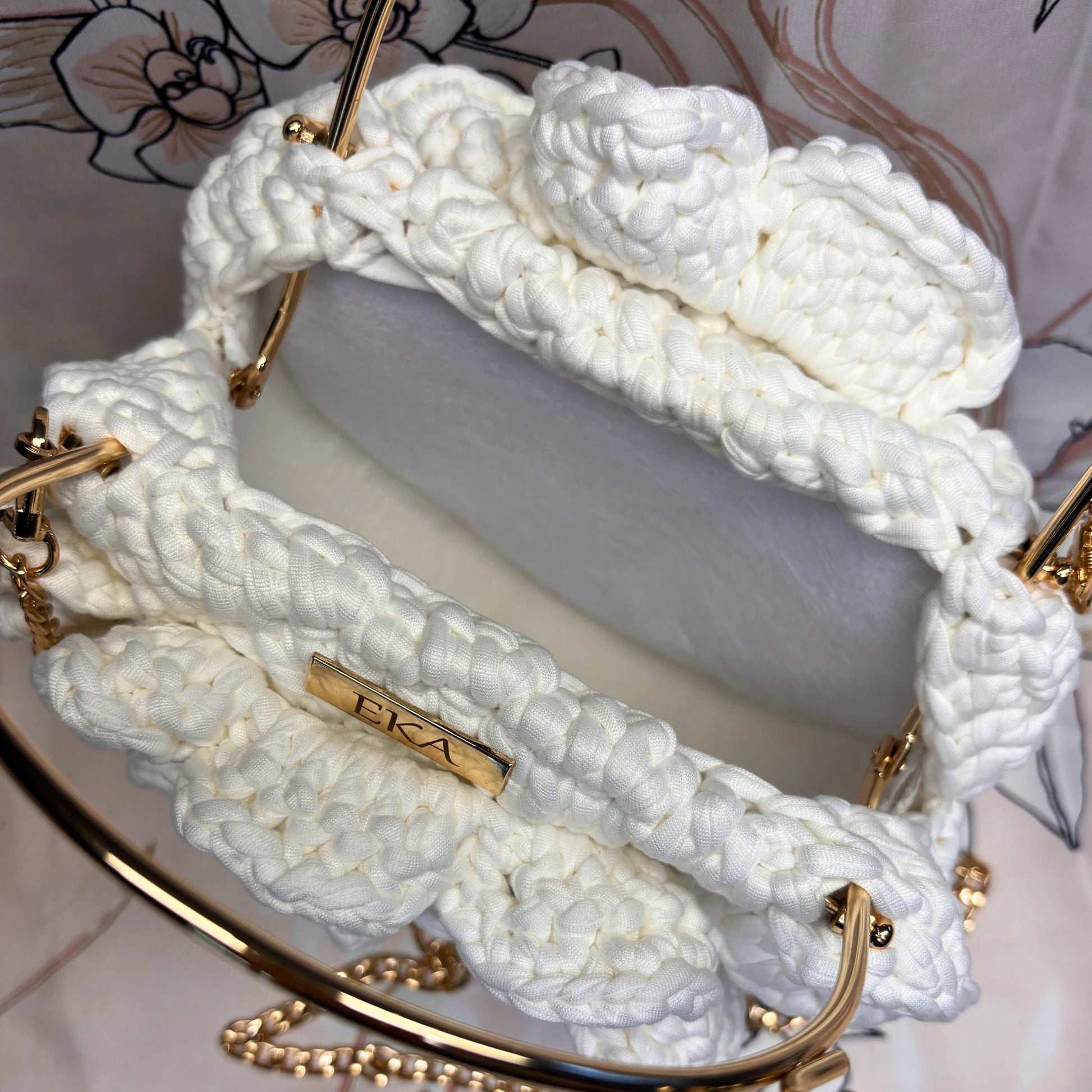 White braided handbag with gold accents on a white background