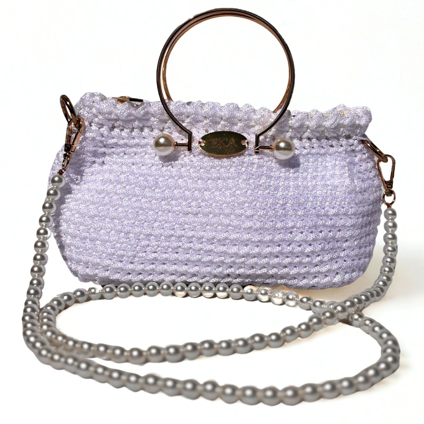 A white crocheted handbag with a gold-tone metal ring handle, pearl accents, and a long silver pearl chain strap, shown on a plain white background.